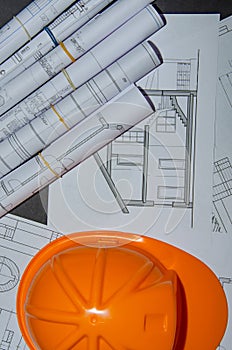 Yellow helmet, house keys and drawing tools on construction plans