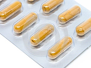 Yellow herb pills transparent gelatin capsule in blister pack