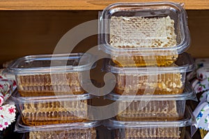 Yellow Honeycomb slices packed in plastic boxes closeup during food festival market, for sale