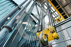 Yellow hook and chain of the factory bridge crane