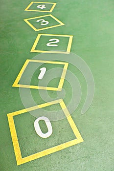 Yellow Hopscotch on Green Playground