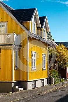 A yellow house with a black roof and white trim photo