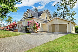 Yellow house exterior with spring blooming rhododendron