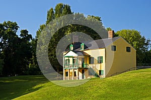 Yellow house on grassy hill