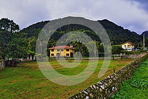 a yellow house between palm trees at the foot of the mountain. On the Way of St. James