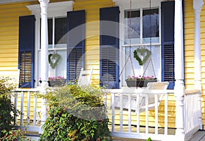 Yellow House, Porch Swing, and Flowers photo