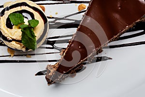 Yellow ice cream ball with chocolate topping and slice of chocolate cake. Forming a gourmet dessert. View from above