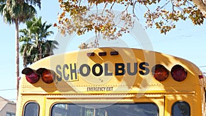 Yellow iconic school bus in Los Angeles, California USA. Classic truck for students back view. Vehicle stoplights for safety of