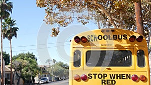 Yellow iconic school bus in Los Angeles, California USA. Classic truck for students back view. Vehicle stoplights for safety of