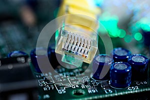 Yellow internet switch on computer circuit board , glowing optical fibres