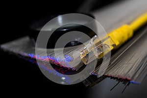 Yellow internet switch , glowing optical fibres, magnifying glass