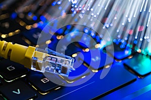 Yellow internet switch on rgb gaming laptop keyboard, glowing optical fibres