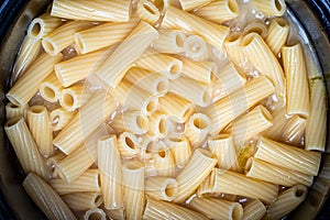 Yellow italian cooked pasta tortiglioni in a pan