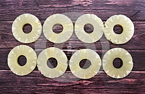 Yellow juicy pineapple rings. Caramelized canned pineapple. Raw food diet. Close-up plan. Woody background.