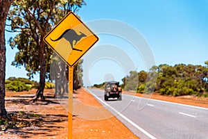 Yellow kangaroo sign on blue sky background