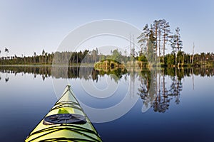 Yellow kayak on a calm forest lake. Kayak in focus, background blurred