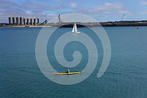 Yellow kayak and sailboat on the Harbour