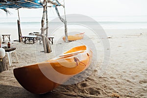 Yellow kayak on sandy beach sea. Two kayaks in sand on background sea.