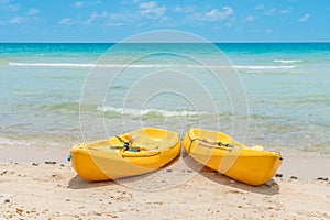 .Yellow kayaks on white sand beach