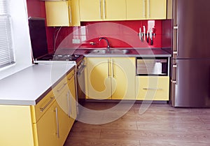 Yellow kitchen with cupboards, window, laminate