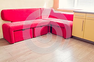 yellow kitchen with cupboards, window, laminate and red soft couch