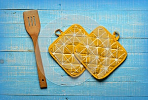 Yellow kitchen pot holders on blue table