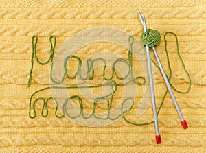 Yellow Knitted Background with Pattern and Braids;Grey Knitting Needle and Green Ball.Hand Made;Fancywork.Sign Hand-made photo