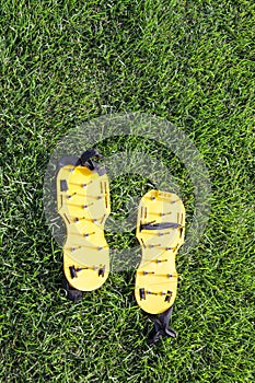 Yellow lawn aerator sandals with nails for lawn cultivation.