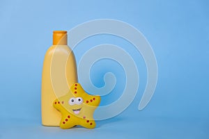 Yellow layout of a children's cosmetic product with a place for a logo and funny toy on a blue background. Baby