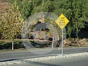 Yellow Left Lane Ends Merge Right Sign on center divider.