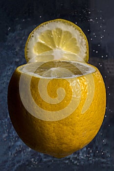 Yellow lemon with clipped top on dark background