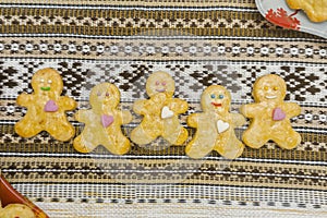 Yellow lemon gingerbread man with candy hearts on a cloth on a wooden table. Homemade cookies with happy smile, sweet christmas
