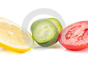 Yellow lemon, green cucumber and red tomato slices