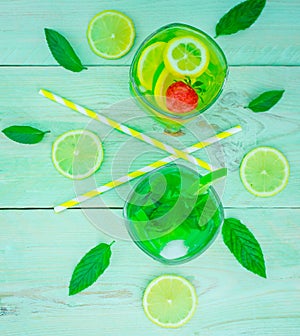 Yellow lemon and lime with fresh  drink in glass green mint on mint colour background