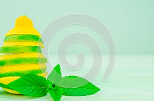 Yellow lemon and lime with fresh green mint on mint colour background