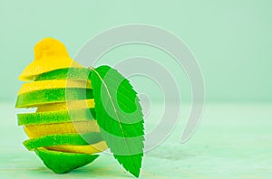 Yellow lemon and lime with fresh green mint on mint colour background