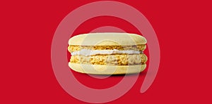 Yellow lemon macaron isolated on red background. with a shadow