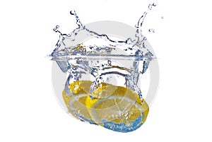 Yellow lemon splashing in clear blue water