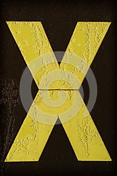 Yellow letter X covered with frost