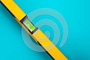 Yellow level tool on blue background. A tubular spirit level. Text space