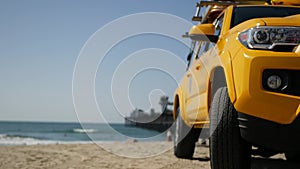 Yellow lifeguard car, ocean beach California USA. Rescue pick up truck, lifesavers vehicle.