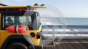 Yellow lifeguard car, ocean beach California USA. Rescue pick up truck, lifesavers vehicle.