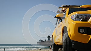 Yellow lifeguard car, ocean beach California USA. Rescue pick up truck, lifesavers vehicle.