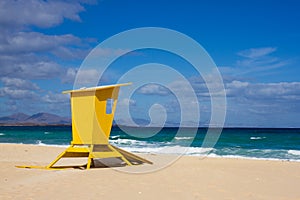 Yellow lifeguard tower. One life guard together red flag on beach. Point of safe, surviving. Coastal view.