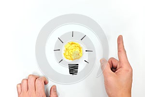 Yellow light bulb crumpled paper with hands in white background. Brand new ideas and innovation concept. Flat lay