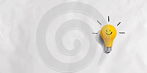 Yellow light bulb with happy face