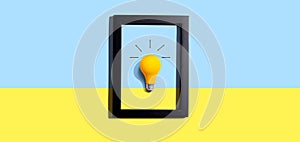 Yellow light bulb inside a frame - inspiration, creativity themes