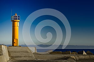 Yellow lighthouse on breakwater dam