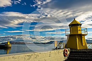 Yellow lighthouse at the entrance of Reykjavik harbor at early morning