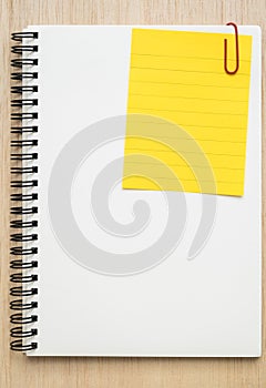 Yellow line memo paper clipped on open notebook